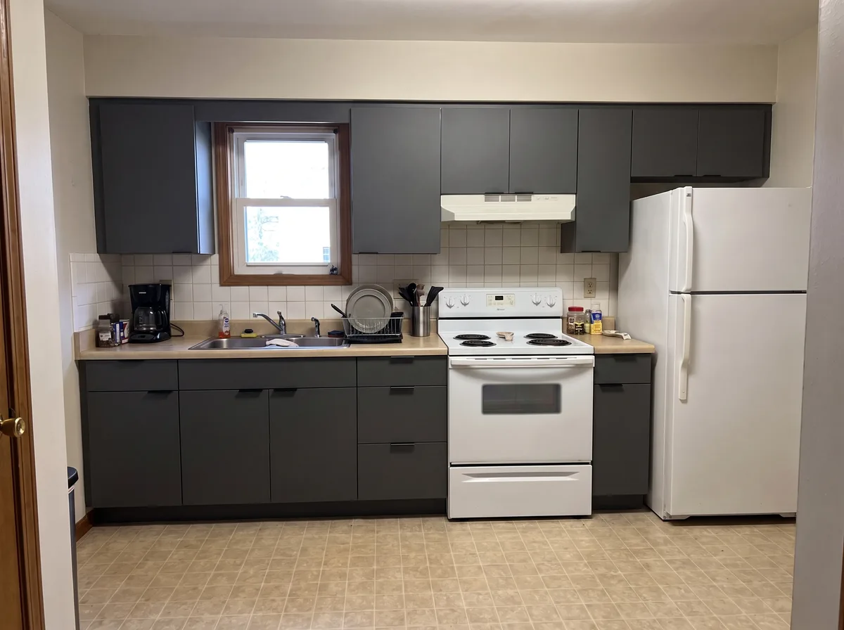The same generated kitchen with flat-front graphite cabinetry — everything else unchanged