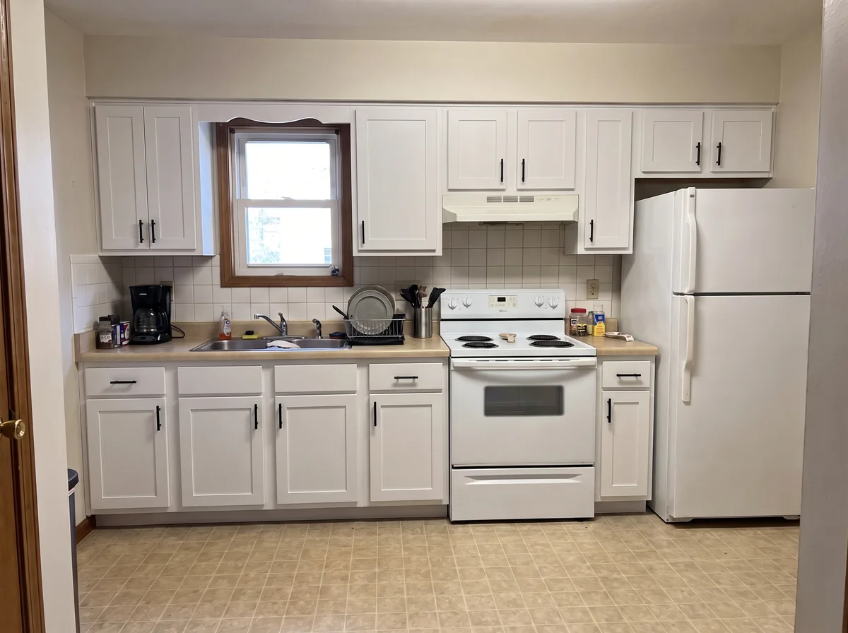 The same generated kitchen with white Shaker cabinetry and matte black pulls — everything else unchanged