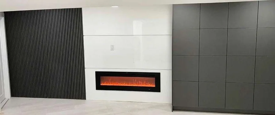 Three-finish wall unit around a linear fireplace with black linear electric fireplace inset, three finishes in one elevation and pale large-format tile floor.