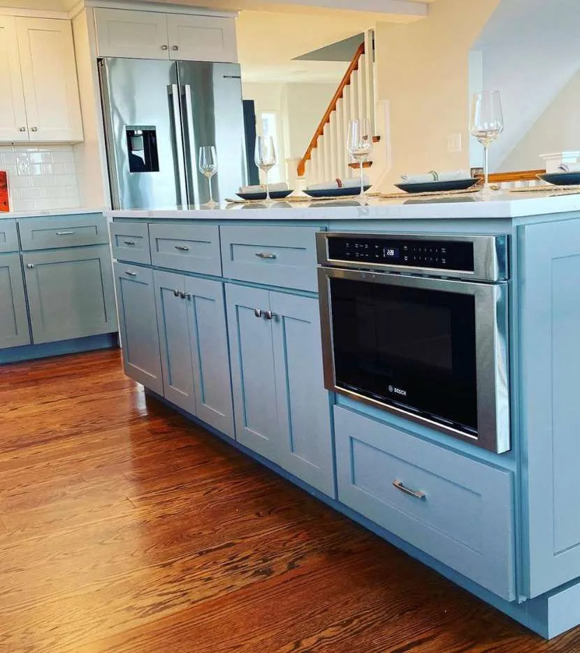 Powder blue shaker island with a microwave drawer, brushed-nickel bar pulls and stainless French-door fridge.