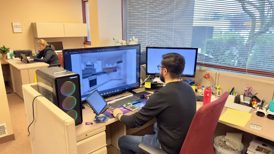 A designer modelling a kitchen at the design desk