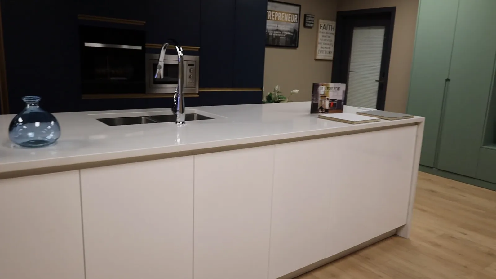 Filmed walk-through of the showroom: kitchen displays, a tall pantry opening, a soft-close drawer, the finish wall, the vanity and the closet